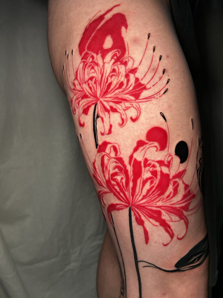 Tatuaggio trash polka di Lenny Fastidio, gigli ragno rossi sul braccio