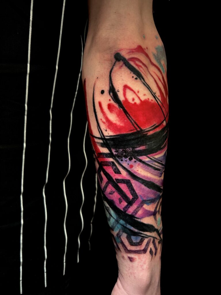 Tatuaggio trash polka di Lenny Fastidio, composizione astratta a colori sull'avambraccio