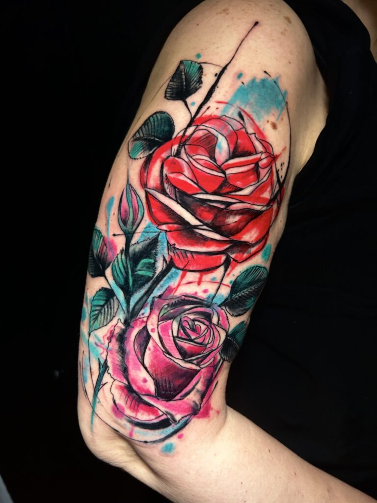 Tatuaggio di Lenny Fastidio, rose rosse e rosa in stile acquerello sul braccio