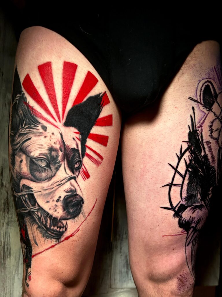 Tatuaggio di Lenny Fastidio, cane con raggi rossi sulla coscia