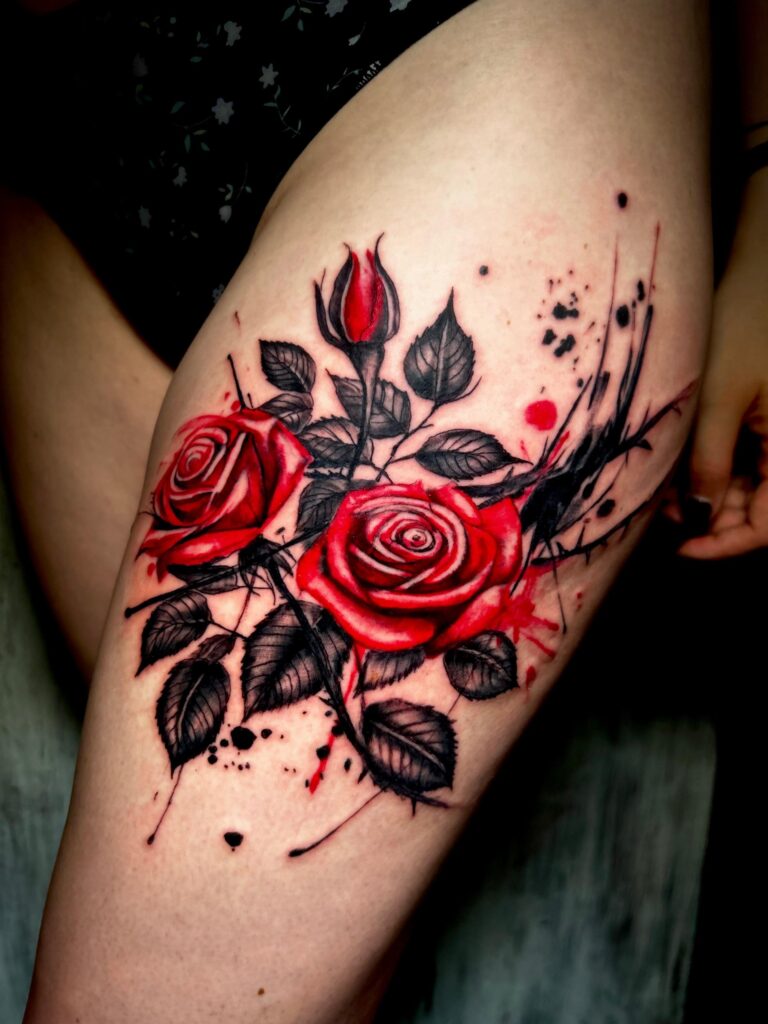 Tatuaggio di Lenny Fastidio, rose rosse e foglie sulla coscia