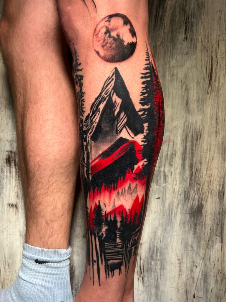 Tatuaggio di Lenny Fastidio, montagna, bosco e luna sul polpaccio