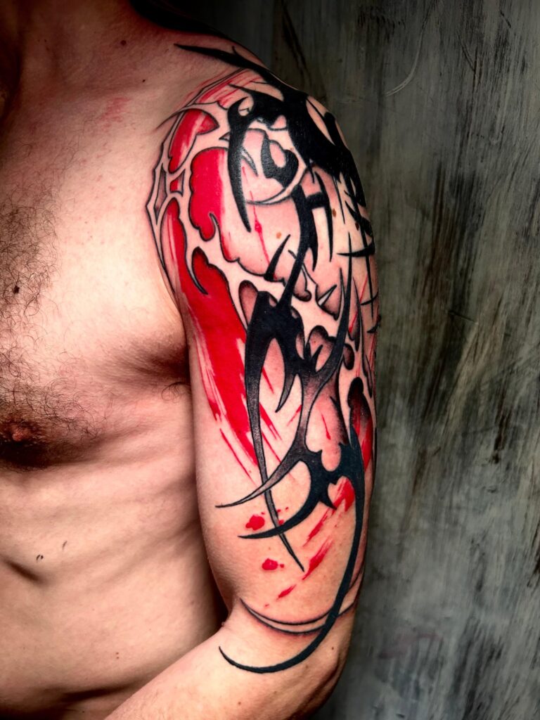 Tatuaggio di Lenny Fastidio, composizione astratta su spalla e braccio