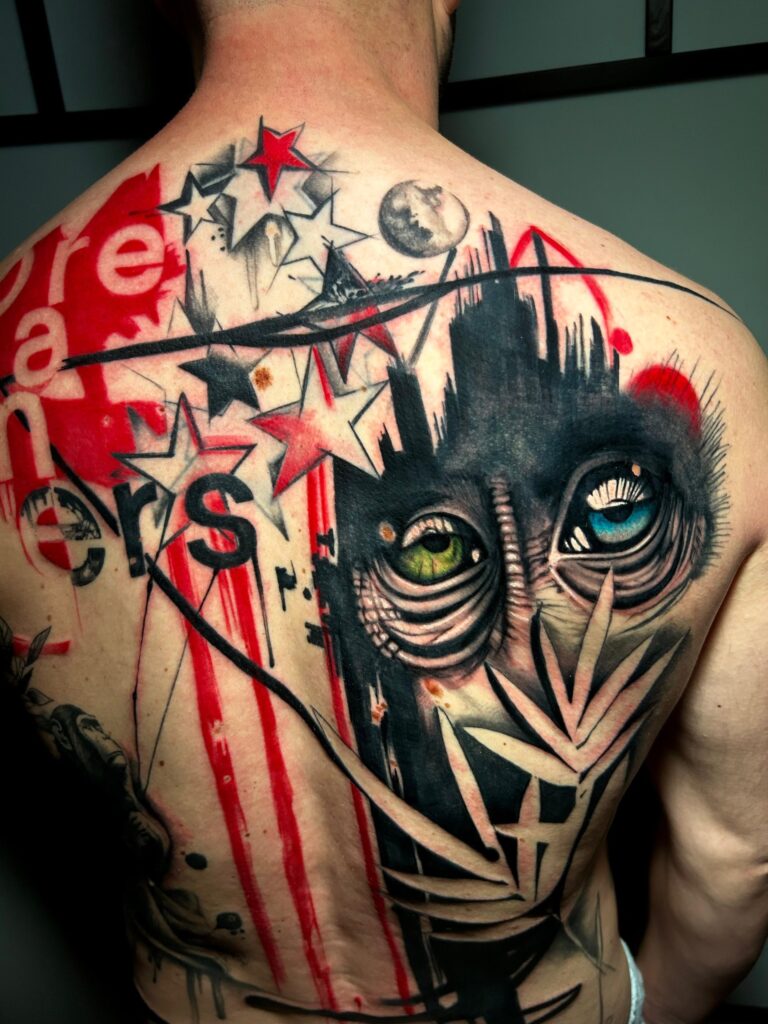 Tatuaggio di Lenny Fastidio, volto con occhi colorati e stelle sulla schiena