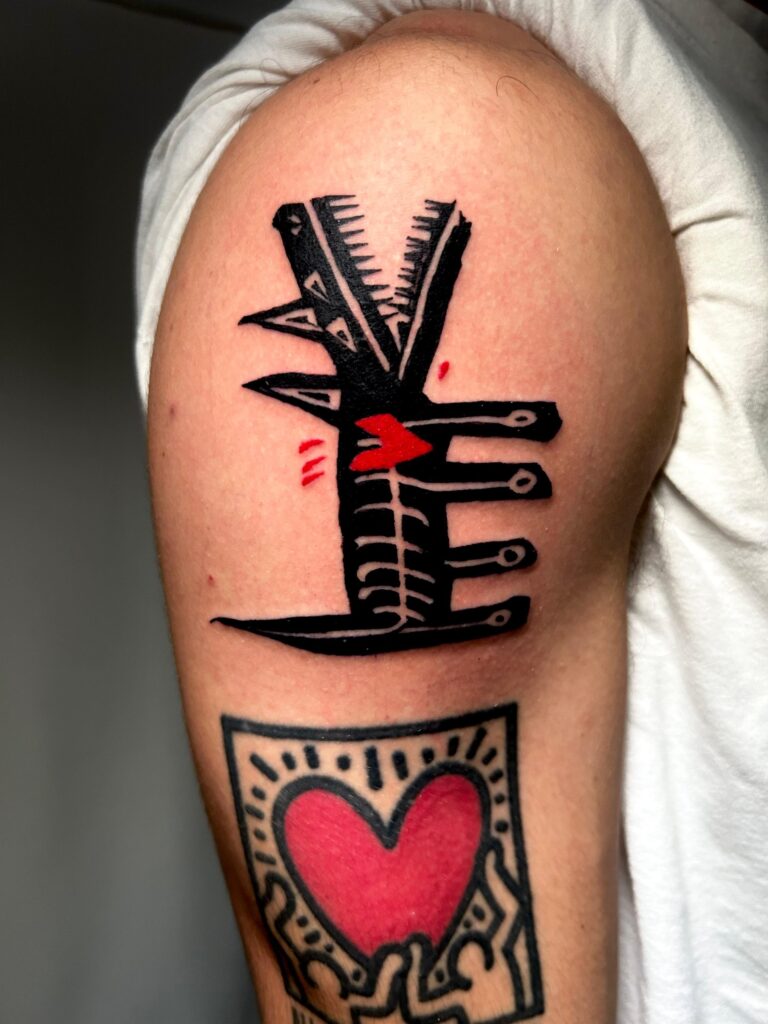 Tatuaggio di Lenny Fastidio, lettering e cuore in stile pop art sul braccio
