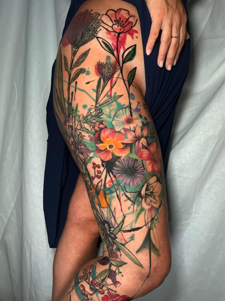 Tatuaggio di Lenny Fastidio, fiori a colori sulla gamba
