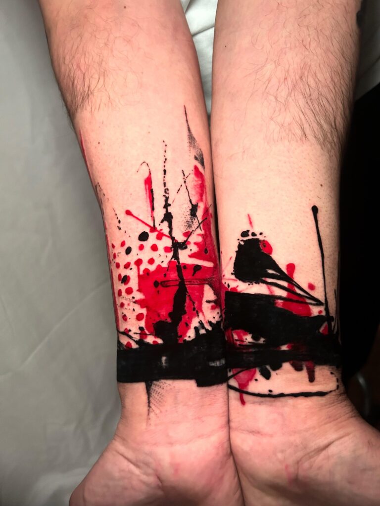 Tatuaggio di Lenny Fastidio, bracciali astratti sui polsi