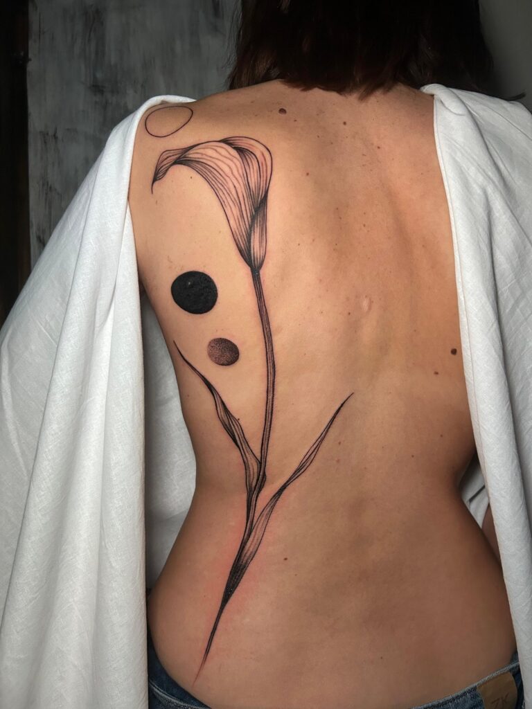 Tatuaggio di Lenny Fastidio, calla e cerchi sulla schiena